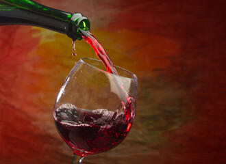 Wine pours into the glass of the bottle