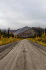 View of Scenic Road, Trees and Mountains on a Fall Day in Canadian Nature. Taken near Tombstone Territorial Park, Yukon, Canada.