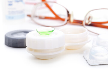 Close-up of green contact lenses in container with solution. , 