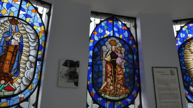 Beautiful colorful stained glass windows inside El Panecillo church, Quito, Ecuador, handheld pan right