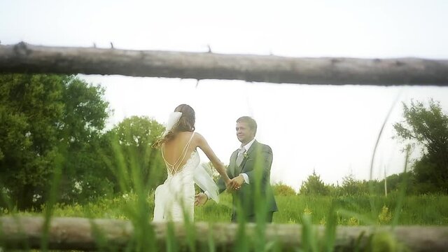 A bride and groom dancing in slow motion at their rustic Kansas wedding in a grassy field full of wildflowers