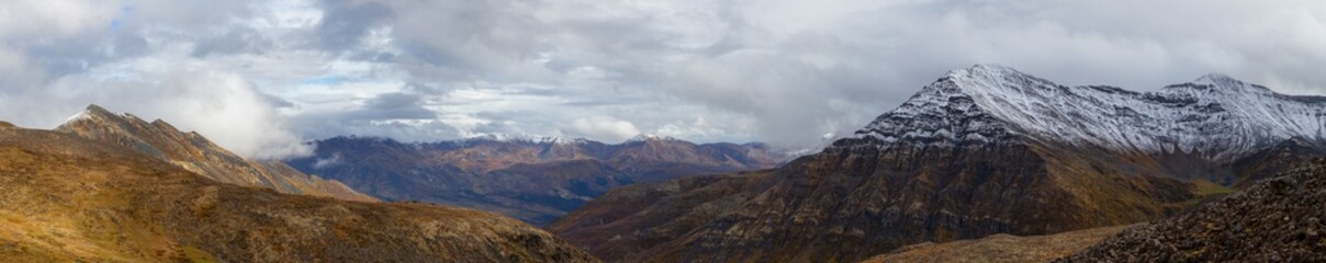 Panoramic View of Scenic Landscape and Mountains in Canadian Nature. Season change from Fall to Winter. Taken near Grizzly Lake in Tombstone Territorial Park, Yukon, Canada.