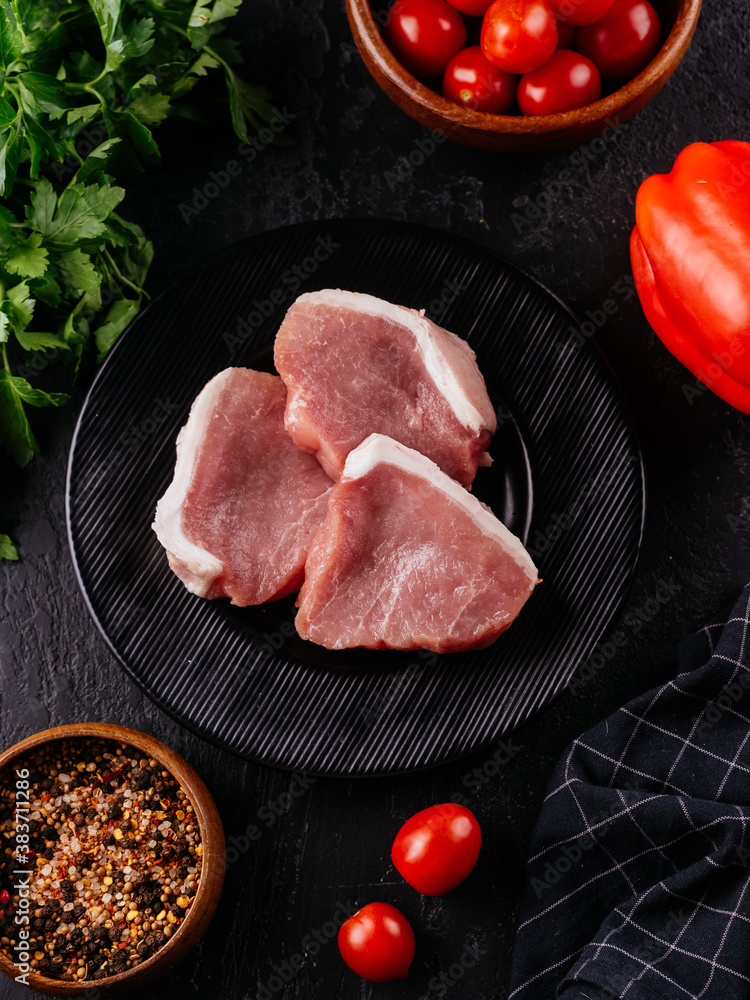 Poster Fresh pork tenderloin on a black plate