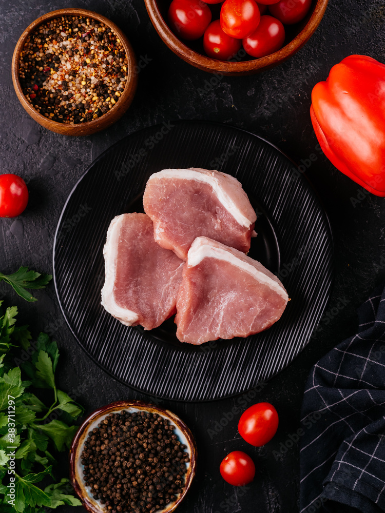 Sticker fresh pork tenderloin on a black plate