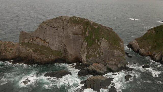 Incredible rugged cliffs with large swell on wild coast of northern Spain, drone