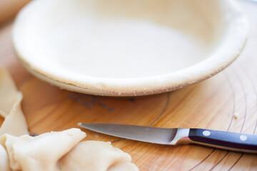 Empty Pie Shell on Wooden Board with Knife