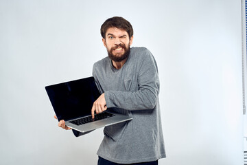 A man holding a laptop internet communication lifestyle technology light background studio