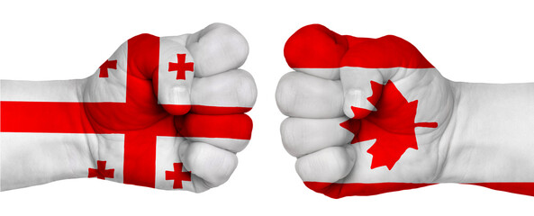 Two hands are clenched into fists and are located opposite each other. Hands painted in the colors of the flags of the countries. Canada vs Georgia