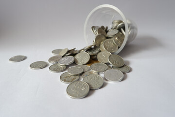 Coins spilling from money jar on white background. Isolated with clipping path photo.