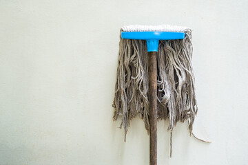 Inverted mop-head wooden handle, close-up shot isolated on white background. Text and copy space available.