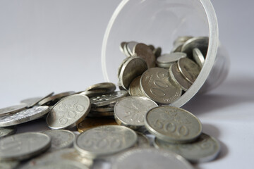 Coins spilling from money jar on white background. Isolated with clipping path photo.