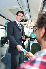 Smiling conductor checking tickets on a tram © Yay Images