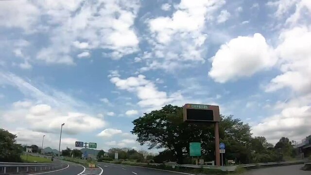 Fast timelapse from moving car with continuous driving in Japan. POV. Fast moving traffic, entering freeway, fast clouds