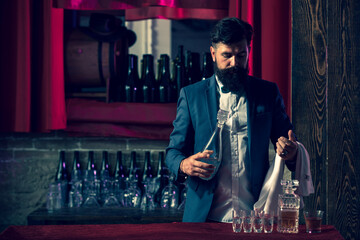 Barman in bar interior making alcohol beverage. Professional bartender.