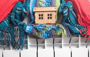 House model and scarf on radiator. Home. Winter. Energy. Efficiency. Heating