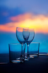Dish of cups and crystal glasses on sea sunset