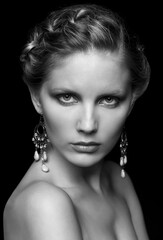 Black and white portrait of young beautiful woman on black
