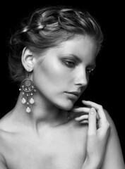 Fototapeta premium Black and white portrait of young beautiful woman on black