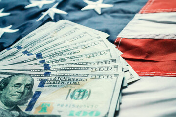 American dollars banknotes on the flag of United States. US dollars background. 100 USD
