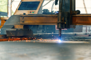 CNC plasma cutting machine cuts a metal sheet. Many sparks and incandescent drops of metal