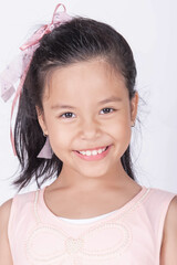 Portrait of cute casual smiling asian girl 8-9 year old posing and looking at camera isolated on light background. Laughing people. Positive emotions. Childhood concept.