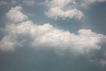 Dramatic sky with fluffy clouds. View from plane window.