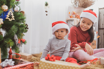 Fototapeta na wymiar cheerful cute childrens girls with gifts. kids wearing pajamas having fun near tree in the morning. merry christmas and happy holidays. loving family with presents in room.