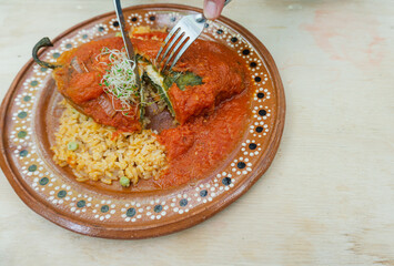 eating with cutlery authentic vegetarian Mexican chili, traditional mexican food, stuffed chili