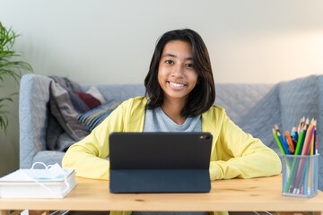 Medium shot. Portrait of Asian woman happy and smile while sitting learning online at home at night.