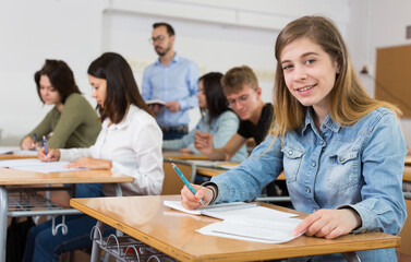 Fototapeta premium Girl is writing test and answer about task in the classroom.