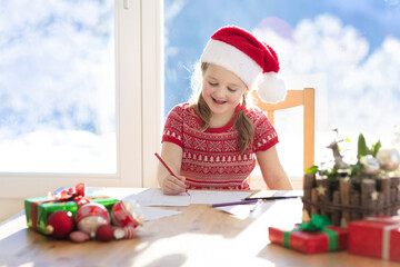 Child writing letter to Santa. Present wish list.