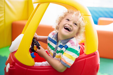 Fototapeta na wymiar Child riding toy car. Little boy with toys.