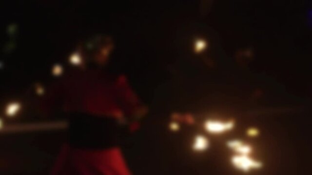 Presentation of a fire show with fire, people show tricks with fire, in the background. Blurry, copy space for text, slow motion