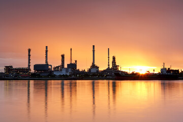 Oil refinery with water reflection at sunrise