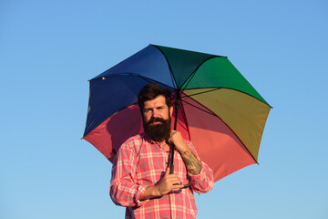 Shoulder portrait of gay man, homosexual male holding rainbow umbrella, colored in rainbow colors. LGBT movement, gay pride banner template.