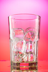 pieces of pure real ice in a glass on a colored gradient background, cubes are rounded