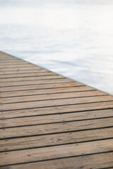Timber brown wood deck platform boardwalk blue water ocean background soft gentle lines sea