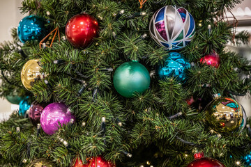 Obraz na płótnie Canvas beautiful green Christmas tree colorful Hanging decoration balls closeup