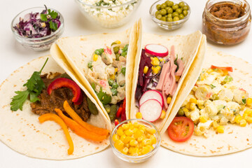 Canned corn in glass bowls. Vegan tortilla wraps with vegetarian salad