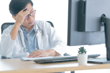 male doctor having a headache while being at doctor's office.