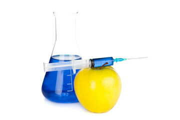 Syringe on an apple next to a beaker