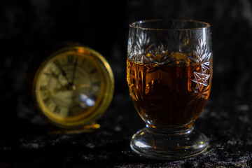 Kurz nach Elf - Schnapsglas steht vor einer Uhr.