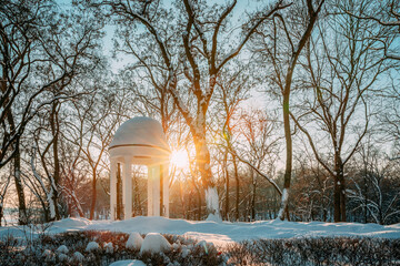 Gomel, Belarus. Winter City Park. Sun at sunset shining through gazebo in city park. Garden pergola...