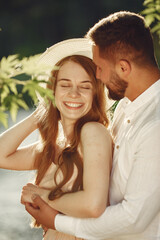 Obraz premium Couple in a field. Brunette in a white t-shirt. Pair sitting on a grass.