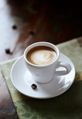 Cup of coffee on rustic wooden background. Close up. 