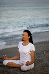 Naklejka na ściany i meble Yoga concept. Female practicing yoga at the beach.