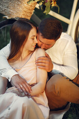 Couple in a field. Brunette in a white t-shirt. Pair sitting on a grass.