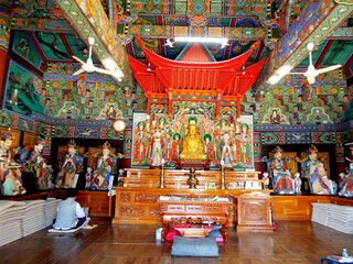 Beomeosa, Busan, South Korea, August 27, 2017: A woman prays inside one of the colorful Buddhist temples in Beomeosa. Busan, Korea.