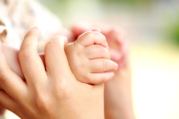 母親と赤ちゃんが手をつなぐ　両手を握って親子の触れ合い