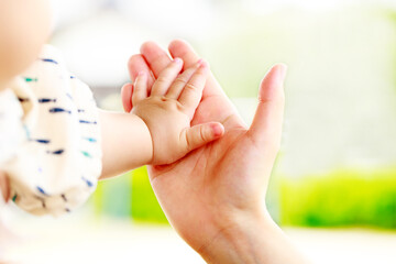母親と赤ちゃんが手をつなぐ　親子の触れ合い